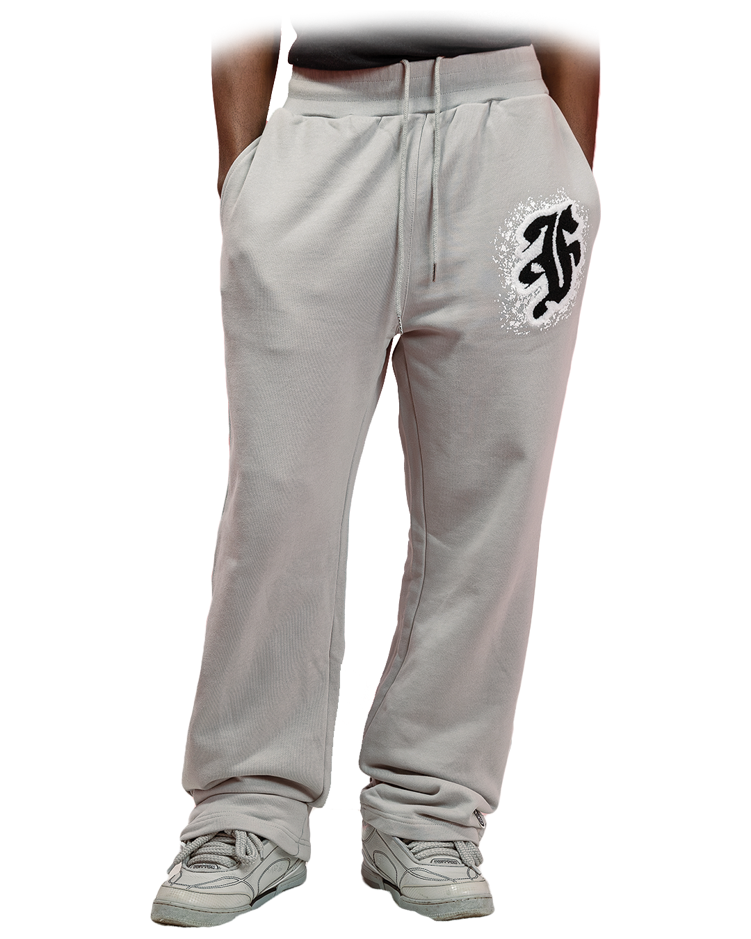 Grey sweatpants with white distressed gothic “F” logo printed on the left thigh and subtle branding on the lower leg.