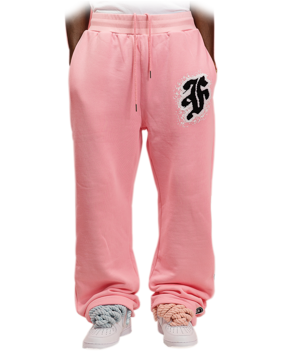 Pink sweatpants with white distressed gothic “F” logo printed on the left thigh and subtle branding on the lower leg.